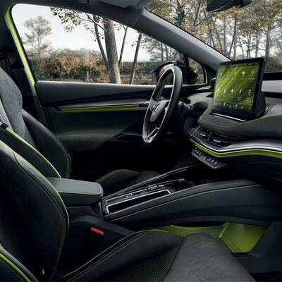 Innenraum des Škoda Enyaq Coupé RS iV mit modernem Display und stilvollen grünen Akzenten. Škoda Auto Röhr.