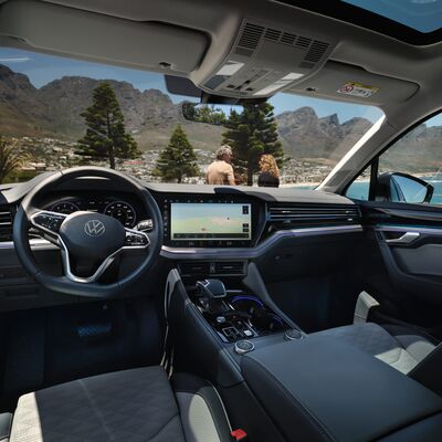 Blick aus dem Innenraum eines Volkswagen auf eine malerische Landschaft, präsentiert von Škoda Auto Röhr.
