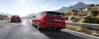 Zwei rote Škoda Octavia RS fahren auf einer malerischen Bergstraße. | Škoda Auto Röhr