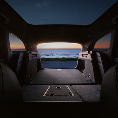 Blick aus dem Kofferraum eines Autos bei Sonnenuntergang am Meer. Škoda Auto Röhr.