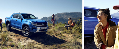 Ein blauer Volkswagen Amarok steht in einer malerischen Landschaft, umgeben von lächelnden Menschen. Volkswagen Zentrum Passau.