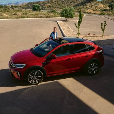 Ein rotes SUV steht auf einem Parkplatz in sonniger Landschaft, präsentiert von Škoda Auto Röhr.