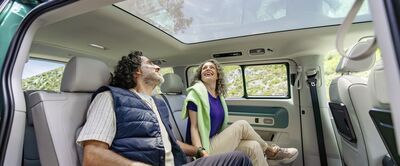 Ein Paar genießt die Aussicht durch das Panoramadach eines Autos von Škoda Auto Röhr.