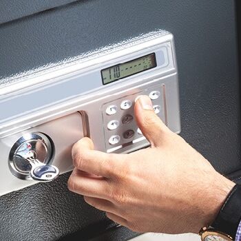 Eine Hand öffnet einen modernen Nachttresor