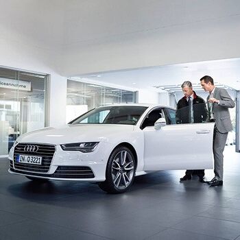 Ein Vertreter zeigt einem Kunden einen weißen Audi als Ersatzwagen im Volkswagen Zentrum Passau.