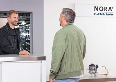 Ein Kunde wird freundlich am Tresen des NORA Profi Teile Service beraten, passend zu Auto Röhr.