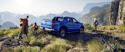 Blauer Pickup auf felsigem Gelände mit drei Personen, die die Aussicht genießen. Abenteuer in der Natur. Škoda Auto Röhr.