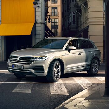 Ein silberner Volkswagen Touareg fährt über eine städtische Kreuzung nahe dem Volkswagen Zentrum Passau.