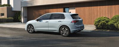 Ein silberner Volkswagen steht vor einem modernen Gebäude, präsentiert von Auto Röhr.