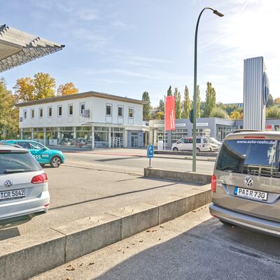 Zwei Volkswagen-Fahrzeuge parken vor dem Volkswagen Zentrum Passau an einem sonnigen Tag.