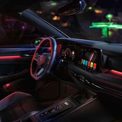 Innenraum eines Volkswagen Golf GTI mit moderner Beleuchtung und digitalen Anzeigen. Erhältlich bei Auto Röhr.