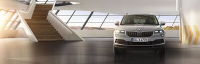 Ein Škoda Karoq steht in einem modernen, lichtdurchfluteten Showroom. Škoda Auto Röhr.