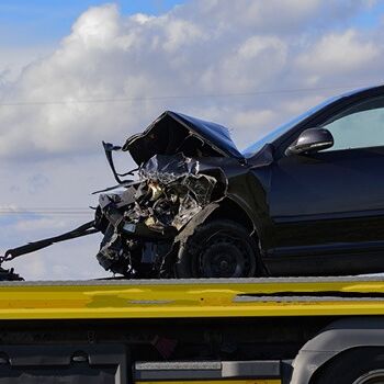Ein stark beschädigtes Auto wird auf einem Abschleppwagen transportiert.
