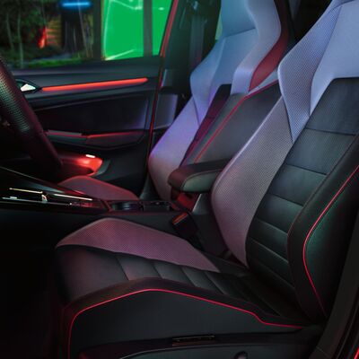 Innenraum eines VW Golf GTI mit beleuchteten Sportsitzen und modernem Design. Erhältlich bei Auto Röhr.