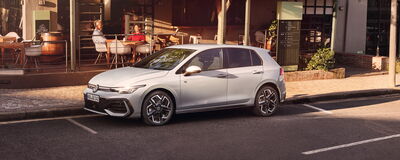 Ein eleganter Volkswagen parkt vor einem Café, das Teil des Auto Röhr Netzwerks ist, und strahlt modernen Stil aus.