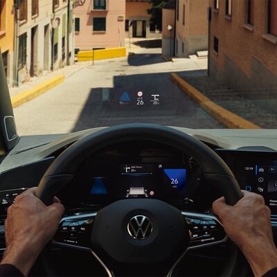 Blick aus einem Volkswagen-Cockpit auf eine enge Straße mit digitalem Display. | Škoda Auto Röhr