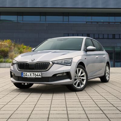 Silberner Škoda Scala parkt vor einem modernen Gebäude. Škoda Auto Röhr.