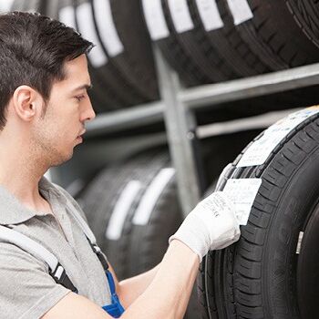 Ein Mitarbeiter überprüft Reifenetiketten in einem Lager bei Auto Röhr.
