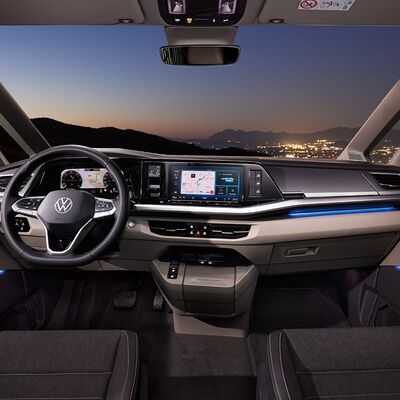 Modernes Volkswagen-Armaturenbrett bei Nacht mit Stadtblick im Hintergrund. Škoda Auto Röhr.