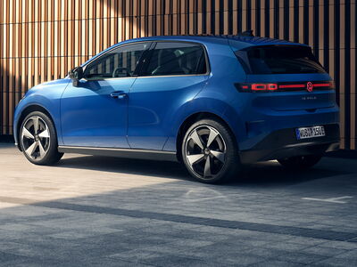 Ein blauer Volkswagen ID. Polo steht stilvoll vor einer Holzfassade, perfekt für Auto Röhr und die Erich Röhr GmbH & Co. KG.
