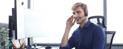 Ein Mann mit Headset bietet freundlichen Kundenservice für Erich Röhr GmbH & Co. KG an einem modernen Arbeitsplatz.