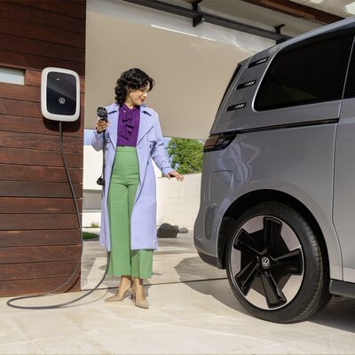 Frau lädt ein Volkswagen-Elektroauto an einer Ladestation auf. | Volkswagen Zentrum Passau.