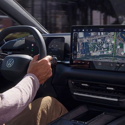 Der Fahrer steuert ein modernes Volkswagen ID.3 Neo mit digitalem Display und Navigationskarte von Auto Röhr.