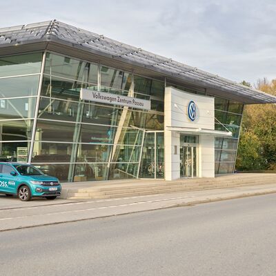 Das Volkswagen Zentrum Passau Firmengebäude mit einem blauen T-Cross davor.