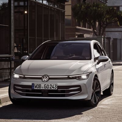 Weißer Volkswagen auf einer städtischen Straße bei Tageslicht, präsentiert von Auto Röhr.