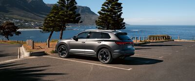 Ein elegantes SUV steht auf einem Parkplatz mit Blick aufs Meer, ideal für Kunden von Auto Röhr.